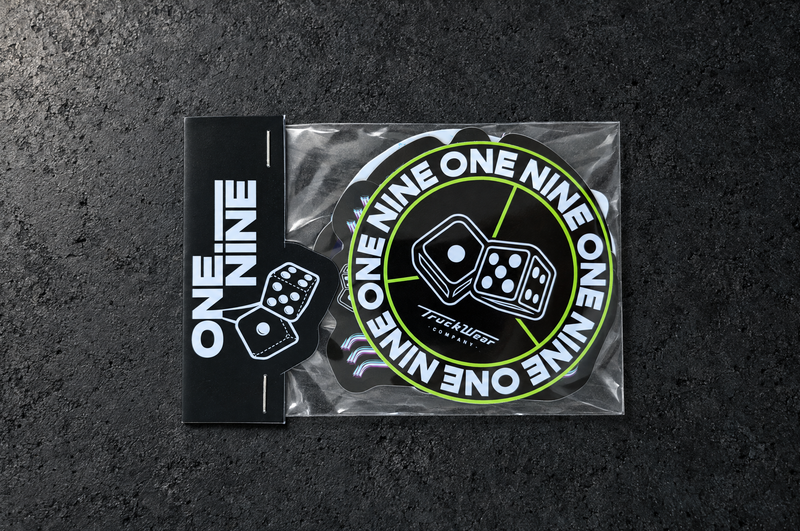 One Nine Budget sticker pack shown at an angle on a charcoal studio surface.