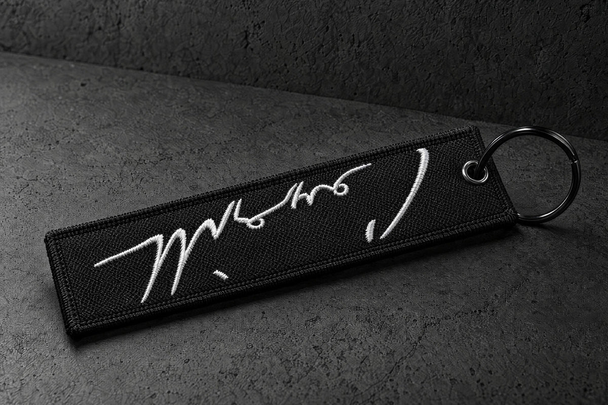 embroidered keyrings on a charcoal studio surface — Projectprint