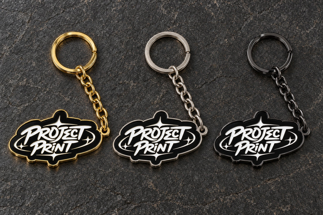 Project Print custom metal enamel keyring design in shiny gold / matt nickel / black nickel, showing three finish options.