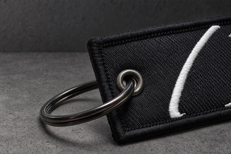 split ring eyelet stitching detail on a charcoal studio surface — Projectprint