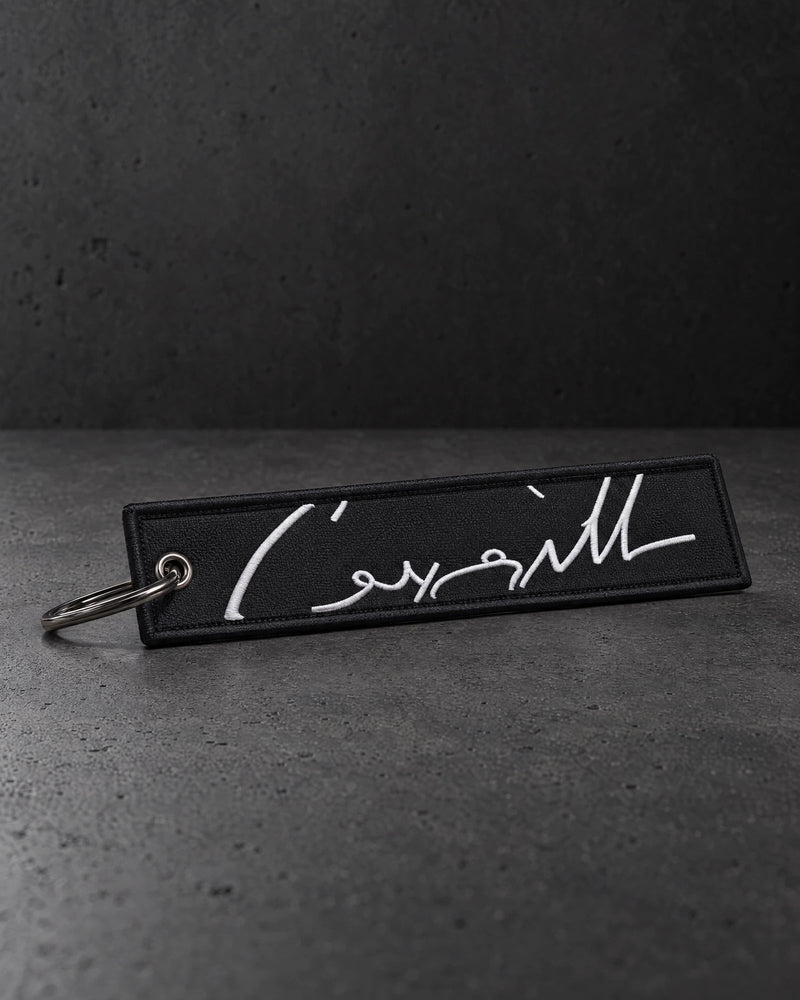 white signature keyring portrait on a charcoal studio surface — Projectprint