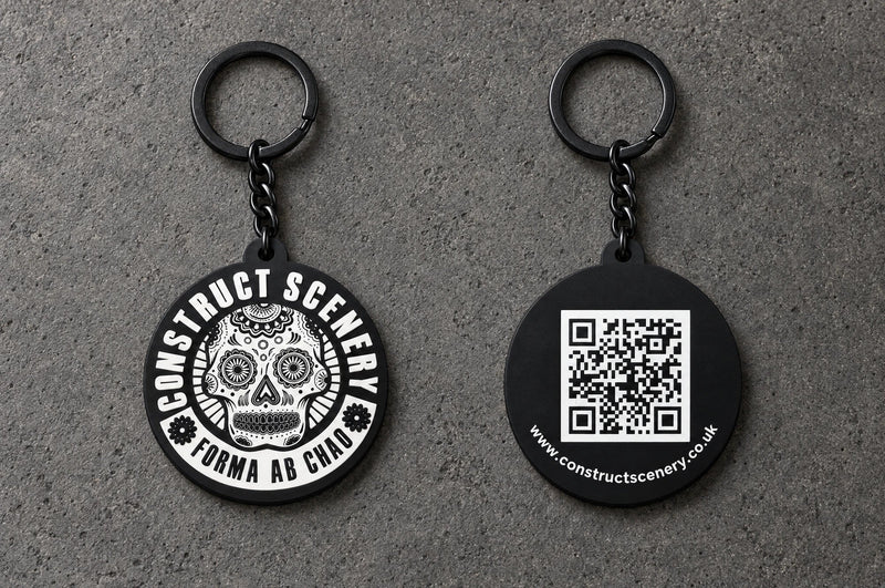 Projectprint custom soft PVC keyring — construct scenery front back, charcoal studio product photograph