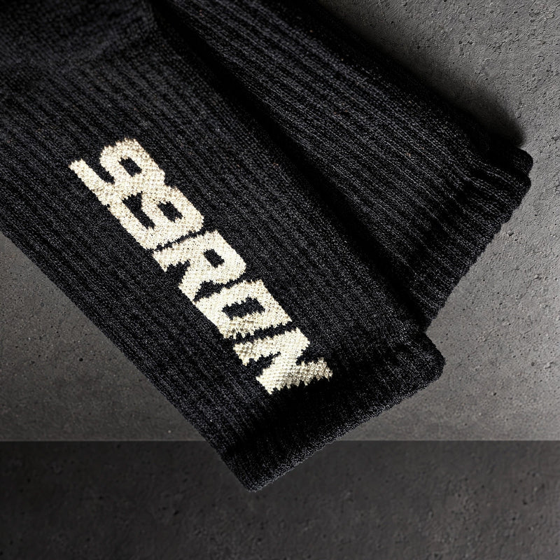99ron knitted lettering detail on a charcoal studio surface — Projectprint