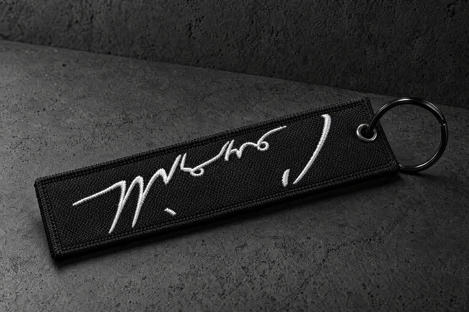 embroidered keyrings on a charcoal studio surface — Projectprint