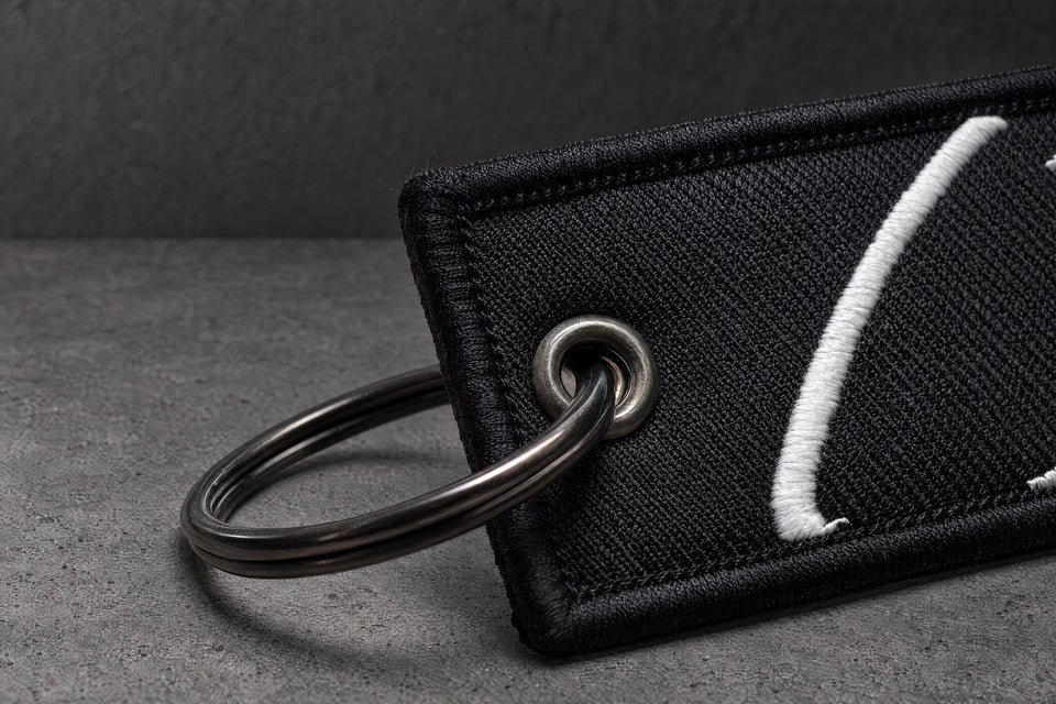 split ring eyelet stitching detail on a charcoal studio surface — Projectprint
