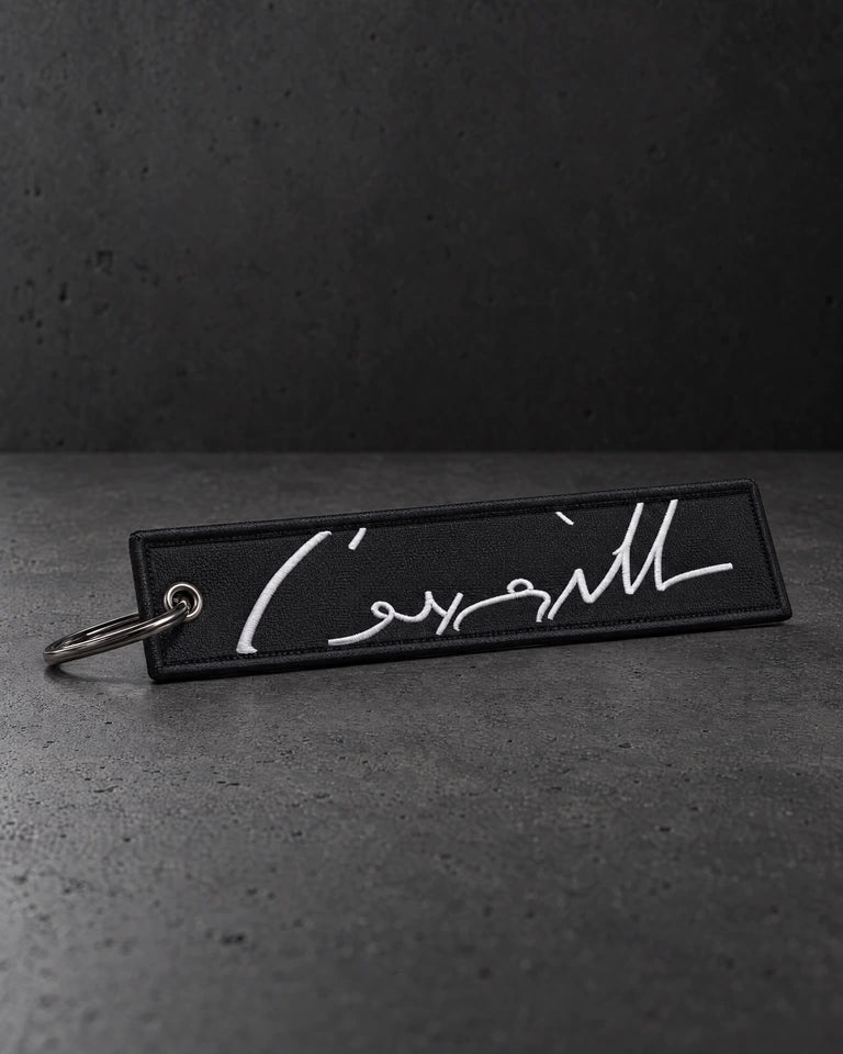 white signature keyring portrait on a charcoal studio surface — Projectprint