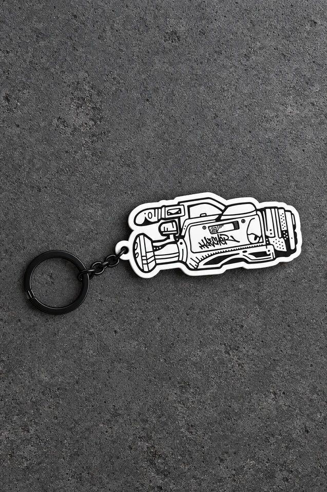 Projectprint custom soft PVC keyring — heat gun, charcoal studio product photograph